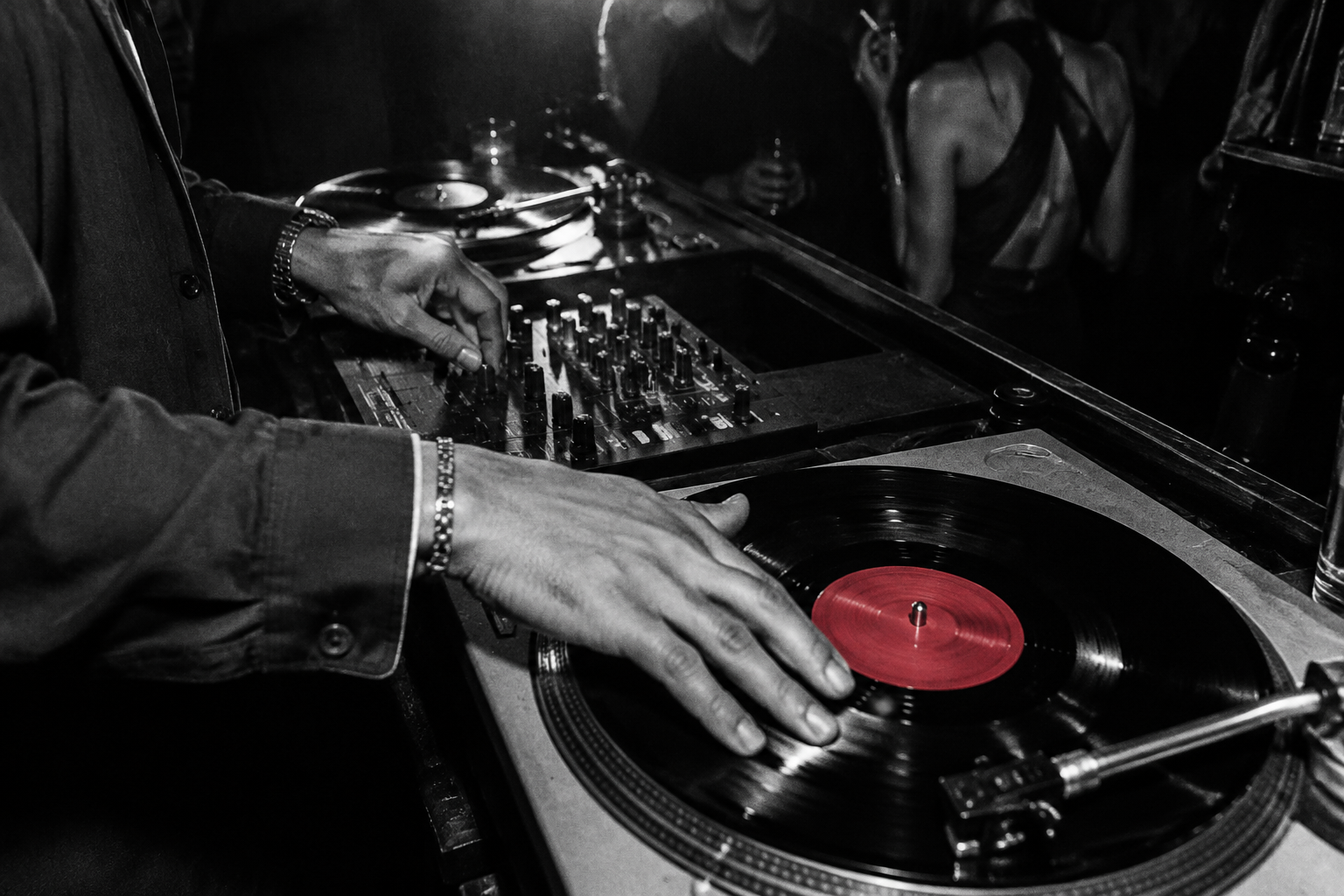 A DJ cueing a vinyl record with a red center label