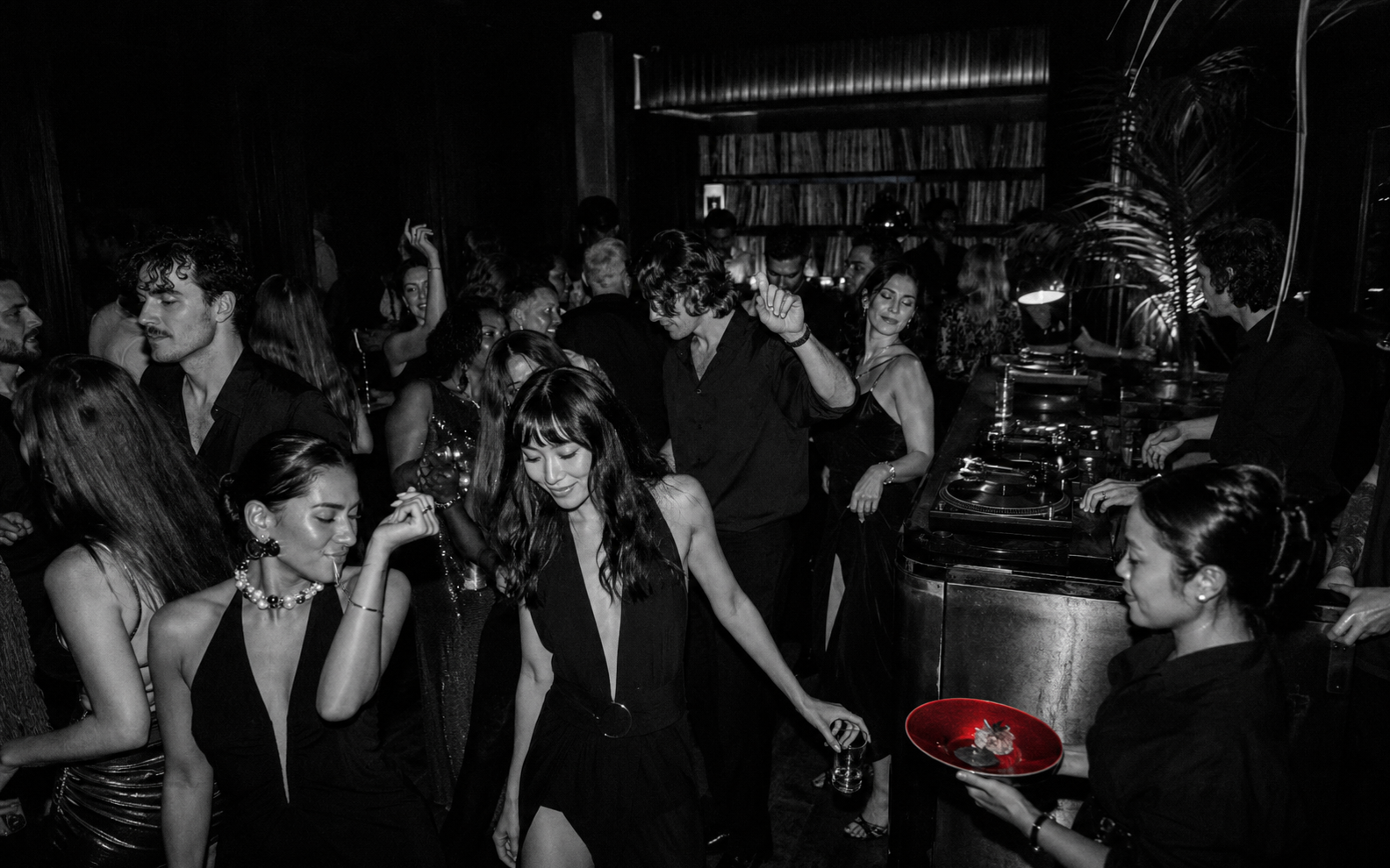 A stylish crowd dancing beside the vinyl booth at YEYE